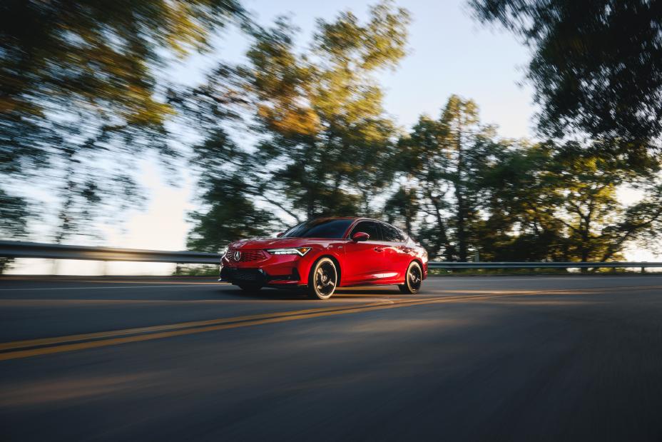 Official Acura photo of a Performance Red Pearl 2026 Integra A-Spec, front three-quarter on a forest road