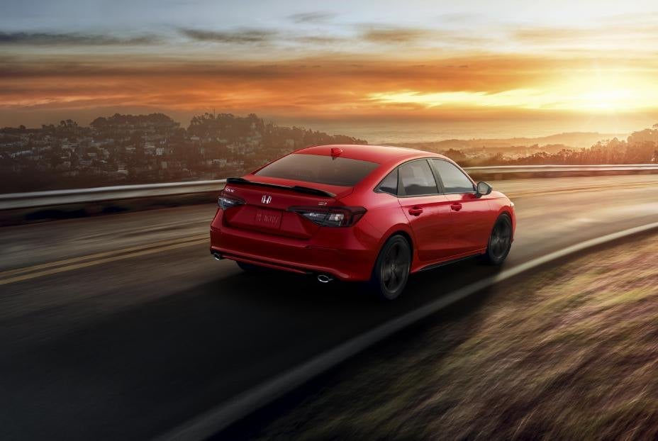 Official Honda photo of a Rallye Red Civic Si, rear three-quarter on a coastal road