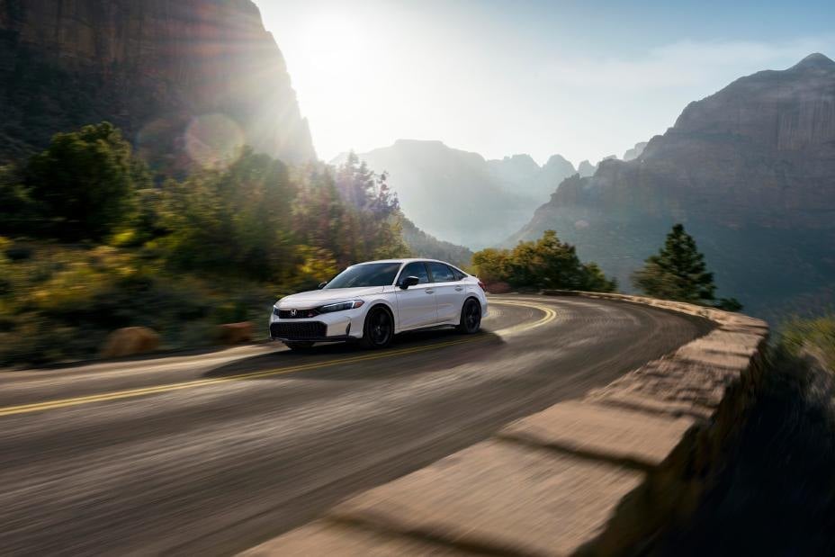 Official Honda photo of a white Civic Si, front three-quarter on a canyon road