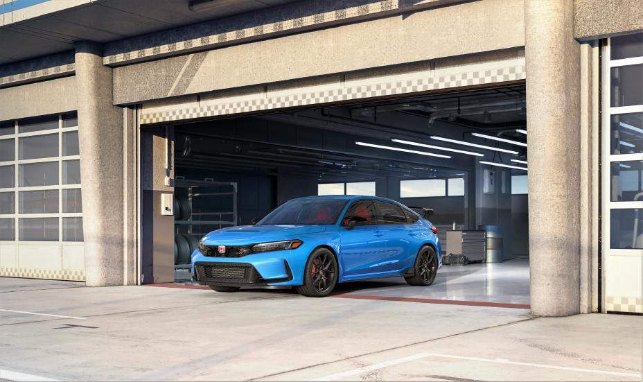 Official Honda photo of a Boost Blue Pearl Civic Type R nose-out of a track garage