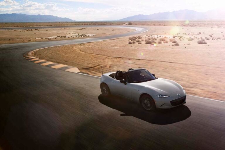 Official Mazda photo of an Aero Gray Metallic 2026 MX-5 Miata soft top on a desert track