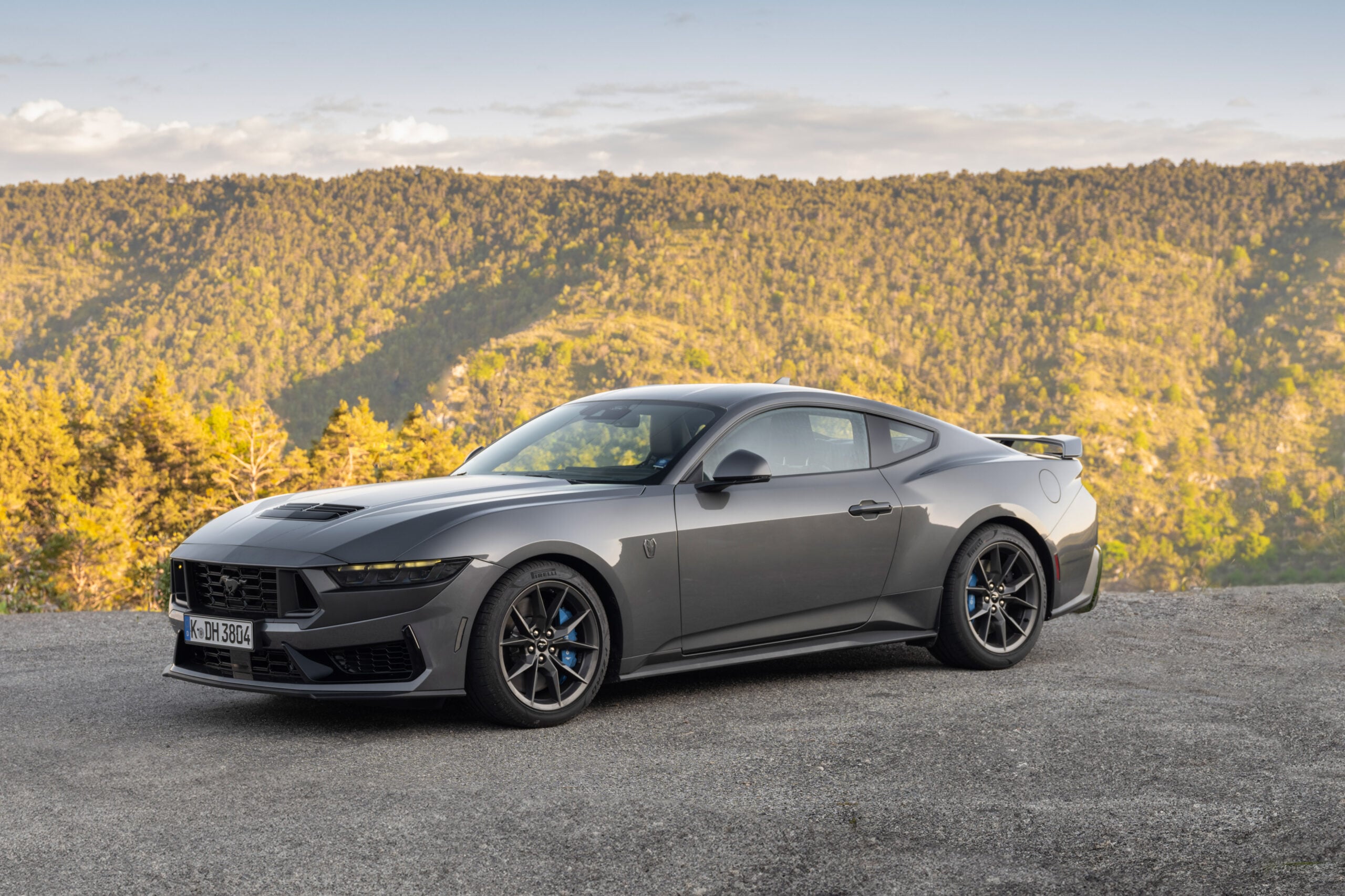Official Ford photo of Carbonized Gray Mustang Dark Horse, front three-quarter overlooking hills