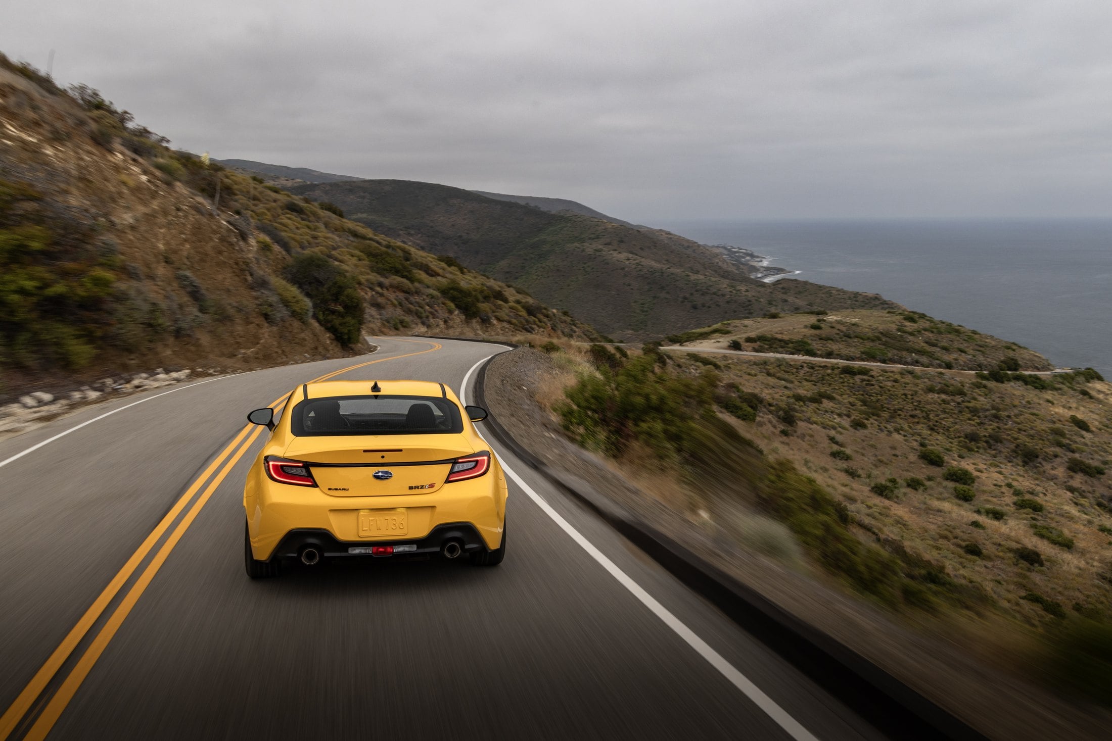 2026 Subaru BRZ Series.Yellow rear three-quarter on a coastal road