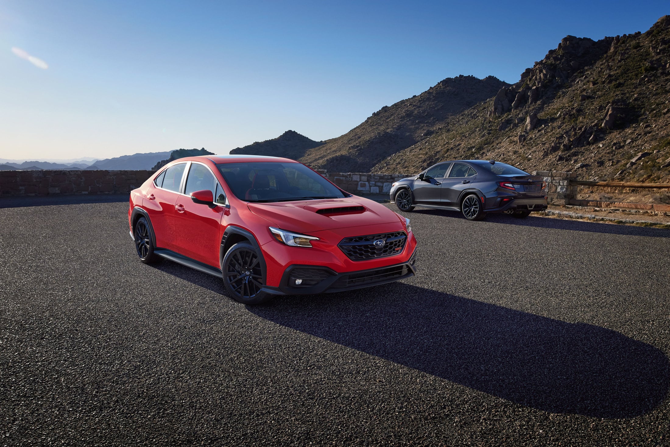 2026 Subaru WRX pair in red and gray at a mountain overlook