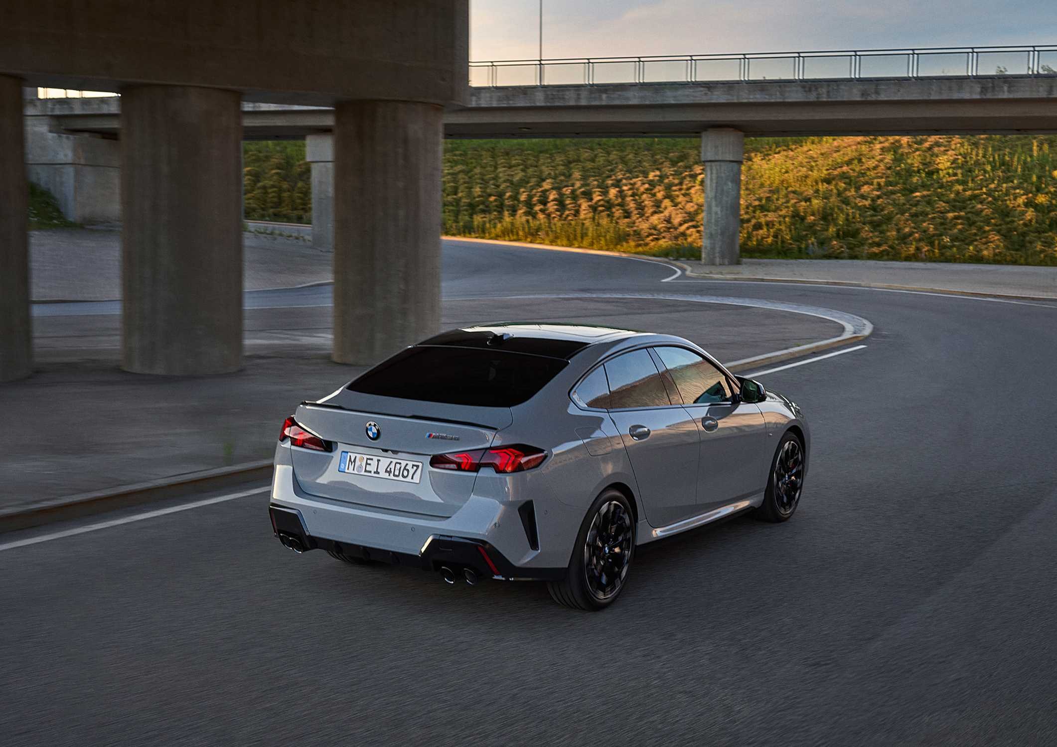 Official BMW press photo of the 2025 M235 xDrive Gran Coupe, rear three-quarter in motion with quad exhausts