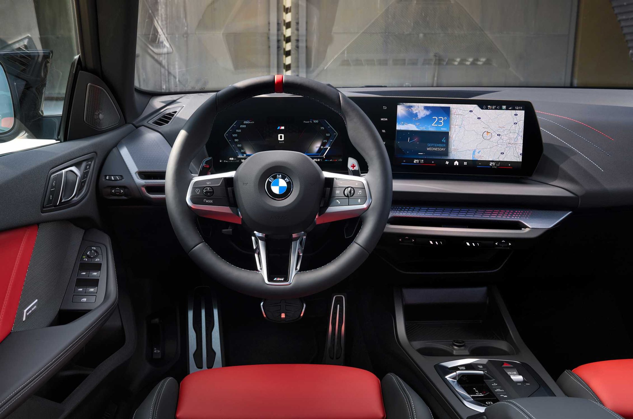 Official BMW press photo of the 2025 M235 xDrive Gran Coupe cockpit with Curved Display and red sport seats