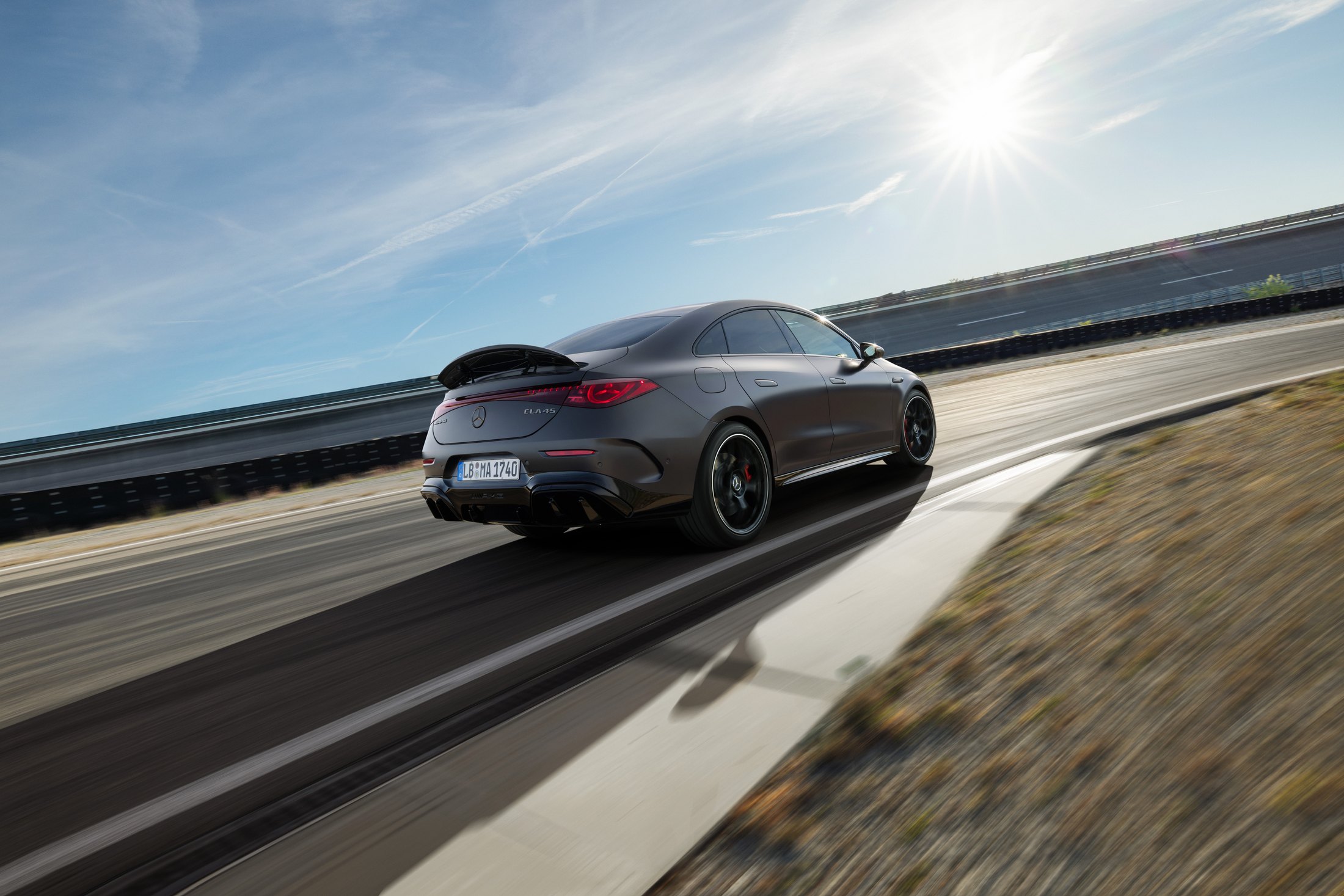 Official Mercedes-AMG photo of the electric CLA 45 4MATIC+, rear three-quarter on a test track with active spoiler