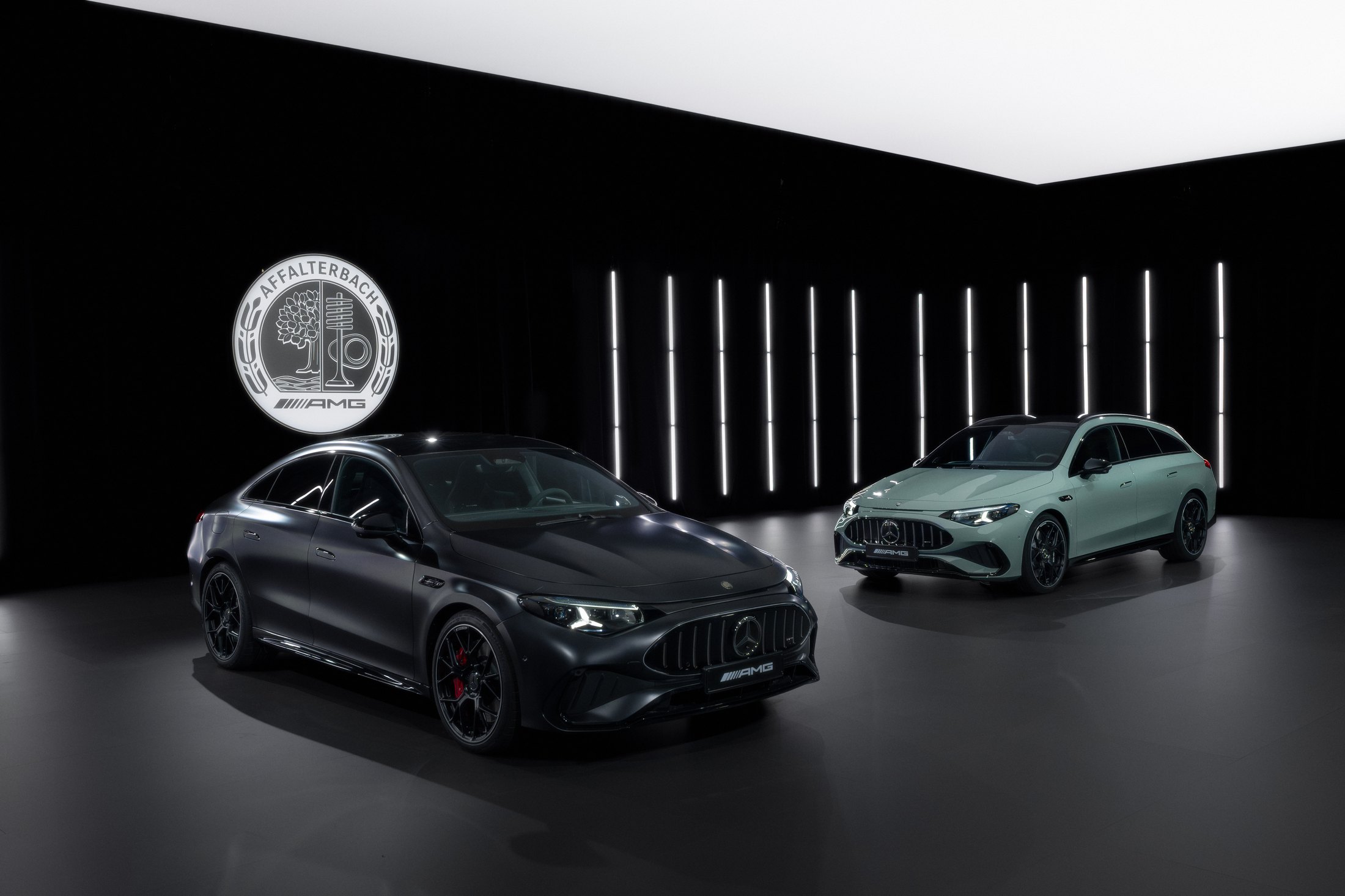 Official Mercedes-AMG studio photo of the CLA 45 sedan in graphite grey magno and the Shooting Brake in aqua-mint, Affalterbach crest on the wall