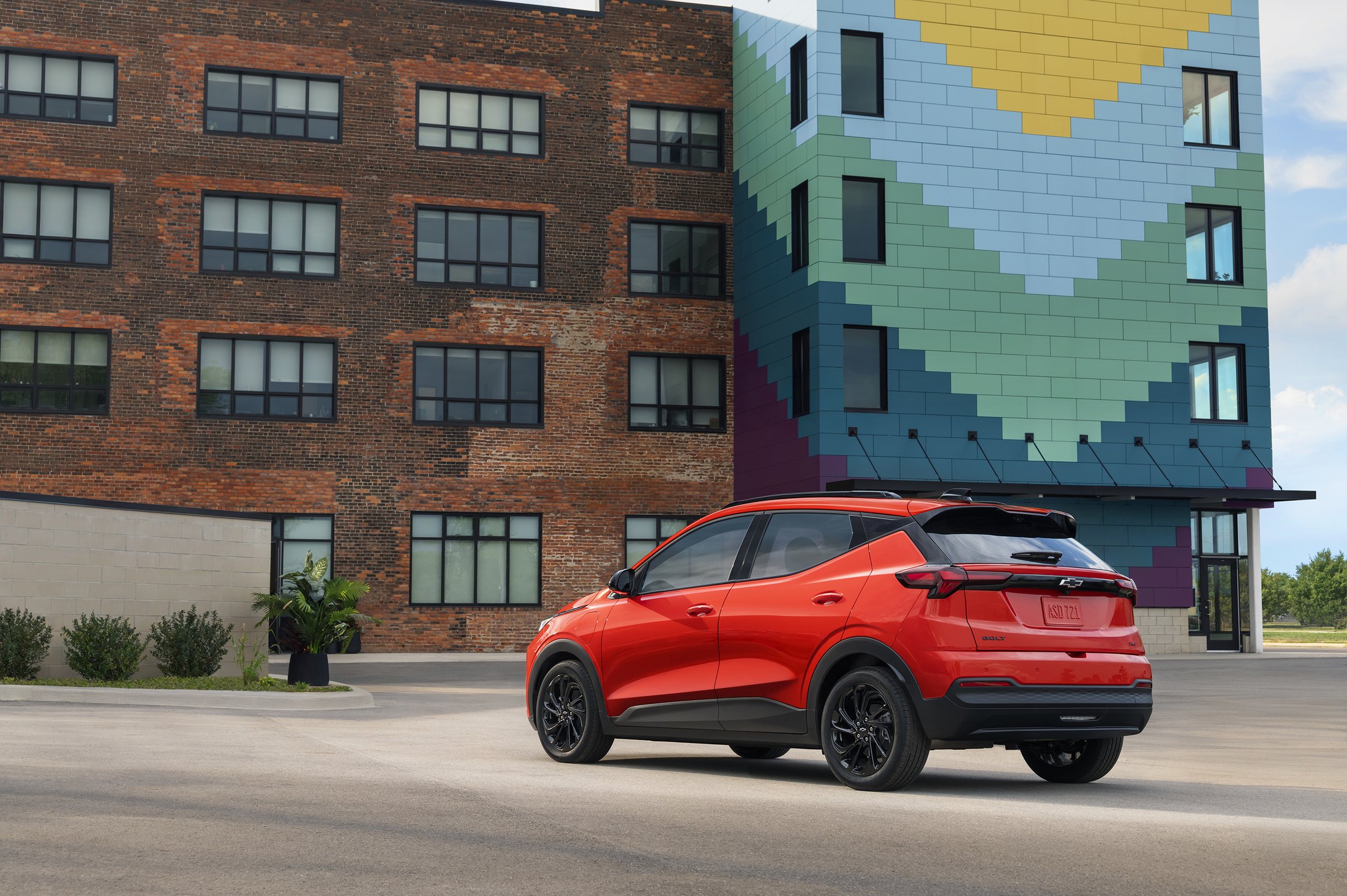 Official Chevrolet photo of the 2027 Bolt RS, rear three-quarter in Habanero Orange