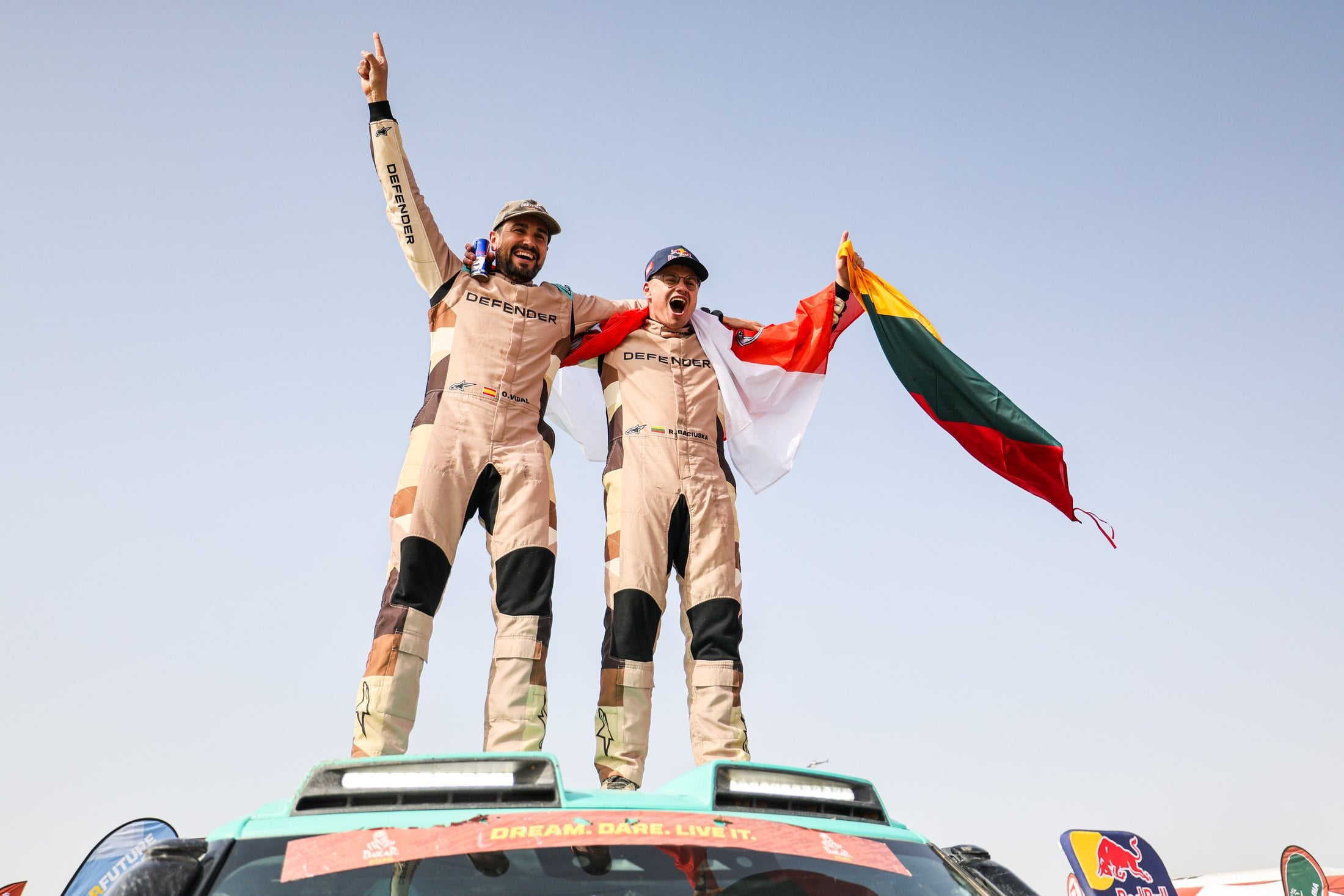 Official photo of Defender Rally drivers celebrating on the D7X-R after winning the 2026 Dakar Rally Stock class
