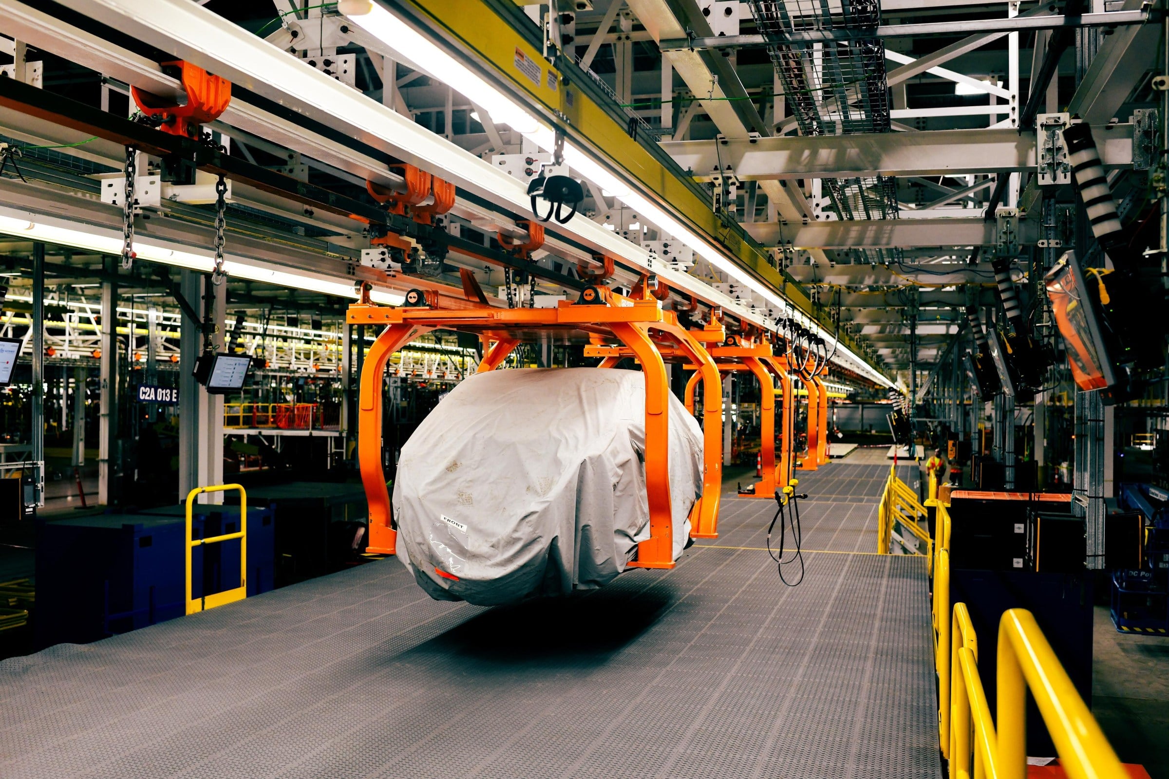 Official Ford photo of a covered Fathom body on the orange assembly-tree carriers at Louisville Assembly Plant