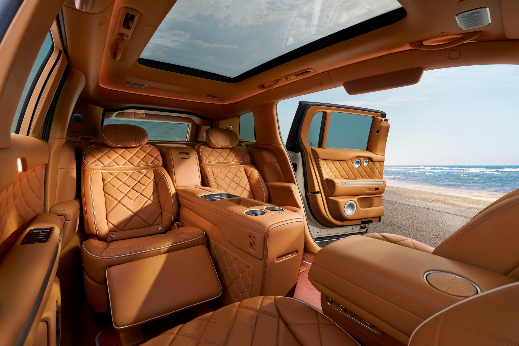 Genesis GV90 Neolun rear lounge with open coach door, quilted tan seats and center console