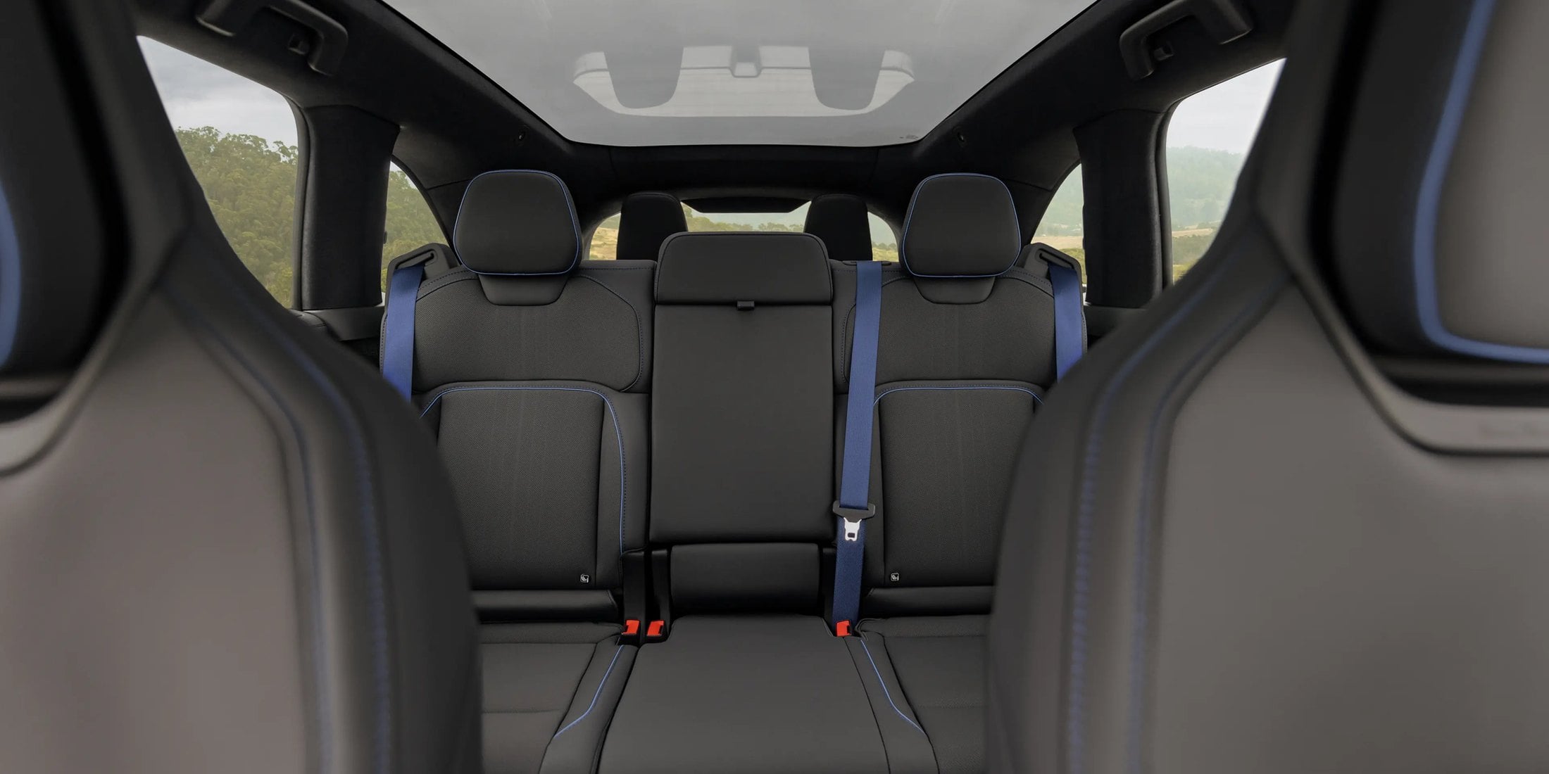 Official Lucid photo of the Gravity GT-S second and third rows with blue seatbelts and a glass roof