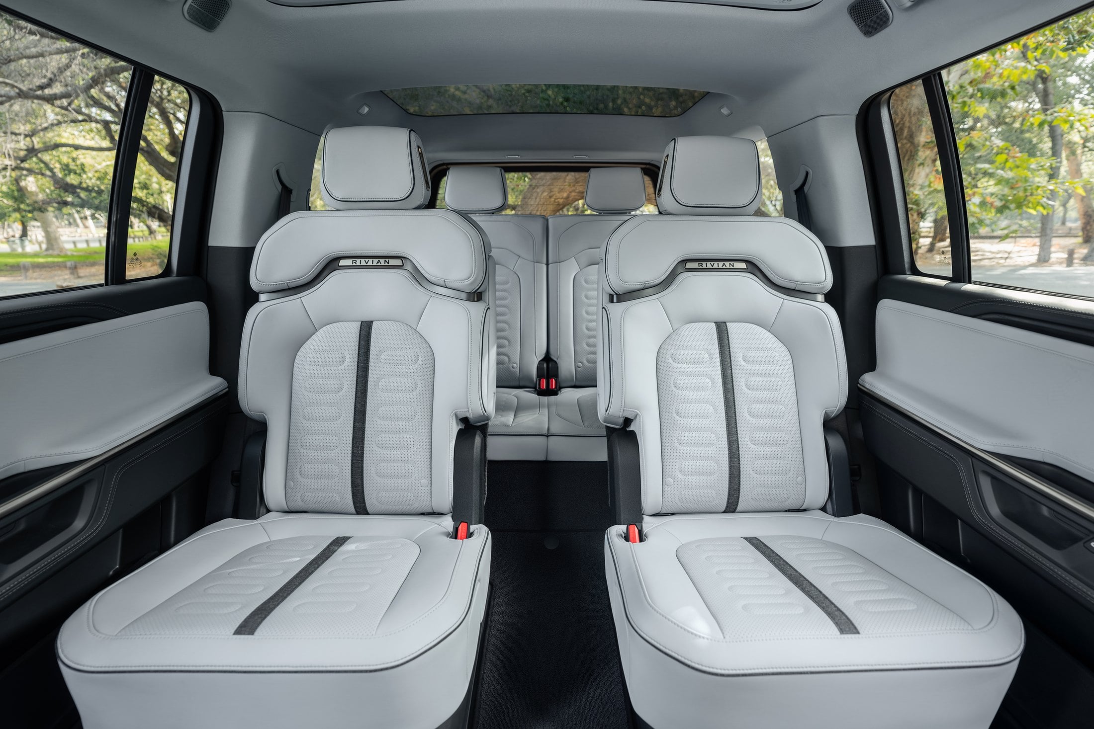 Official Rivian photo of 2027 R1S second-row captain's chairs with a center pass-through to the third row