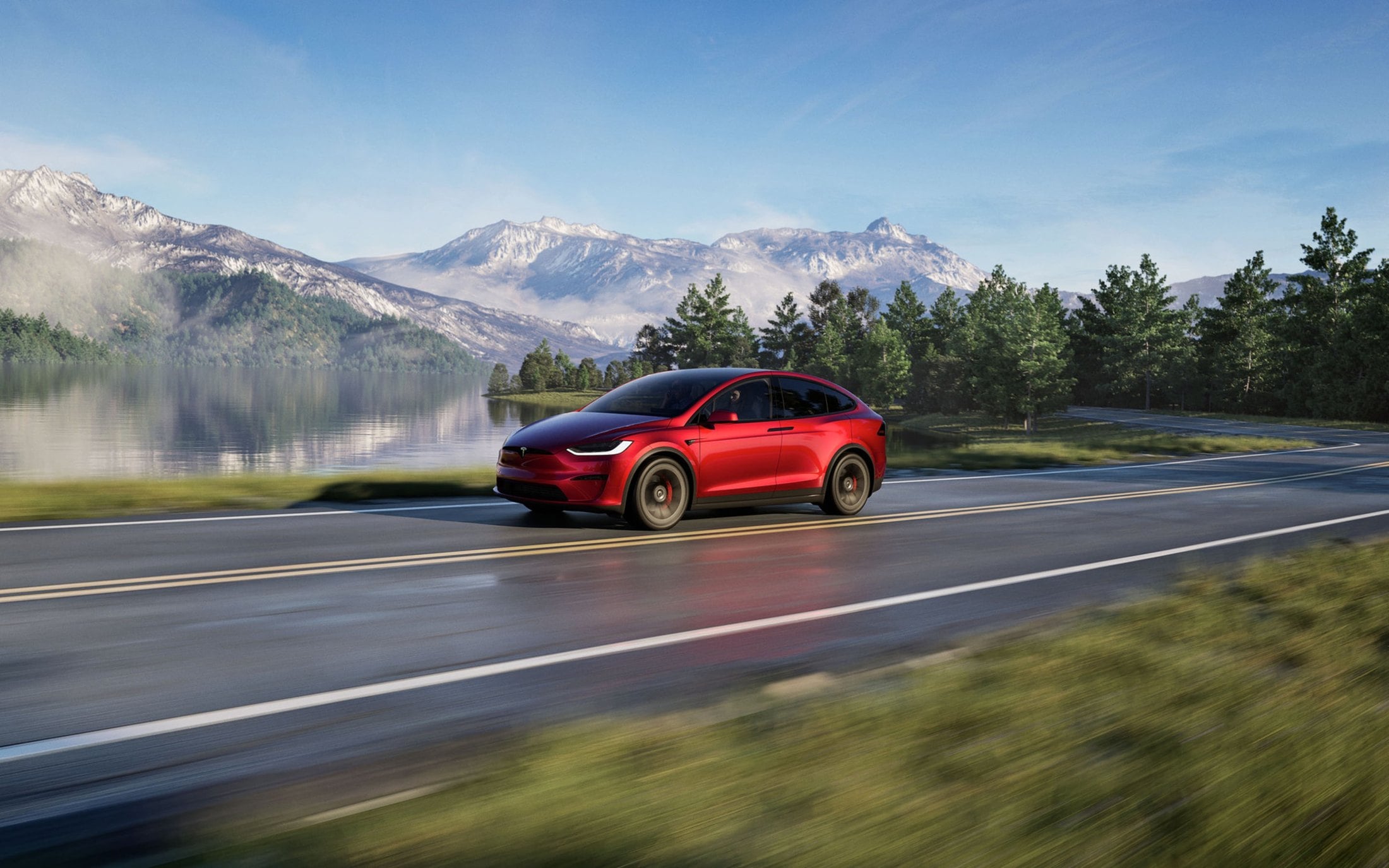 Official Tesla photo of a red Model X Plaid, front three-quarter on a lakeside road