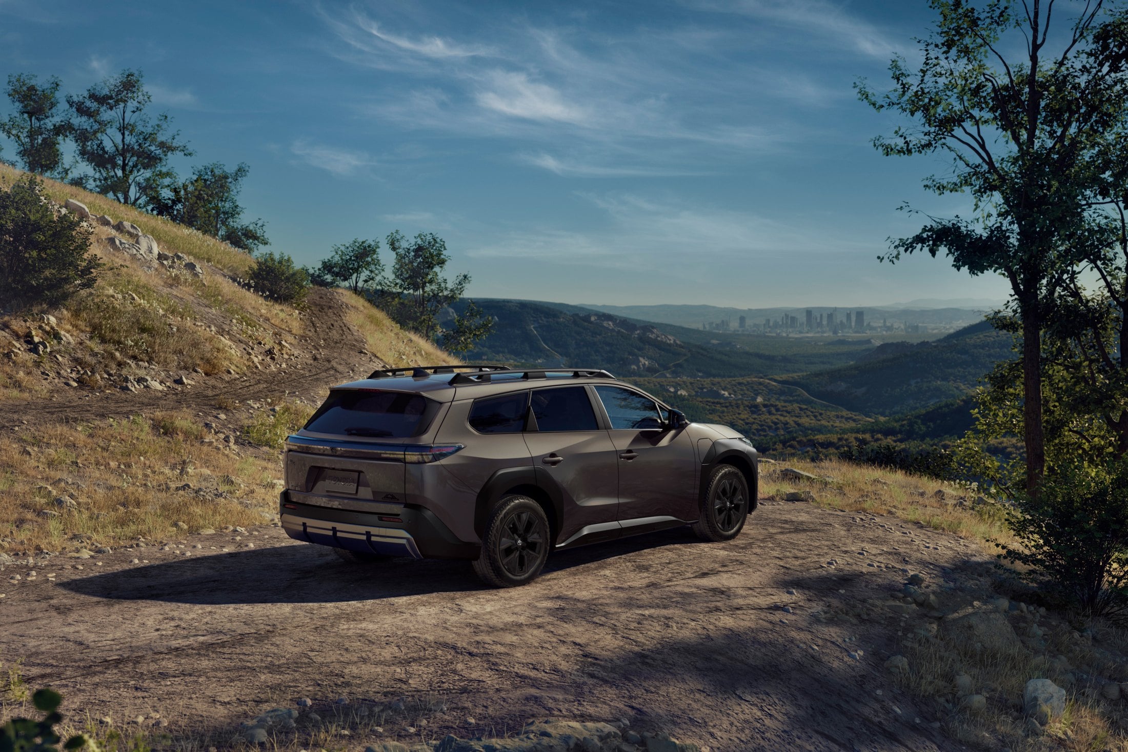 Official Toyota photo of the 2027 bZ Woodland, rear three-quarter on a dirt overlook