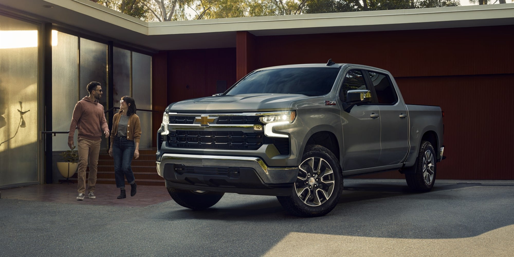 Official Chevrolet photo of a 2026 Silverado 1500 Z71 Crew Cab, front three-quarter at a modern house in late light