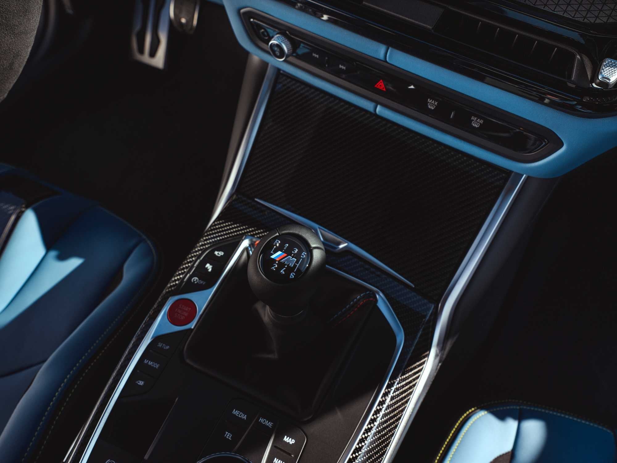 Official BMW photo of the M4 Coupe six-speed manual shifter with M badge and carbon console