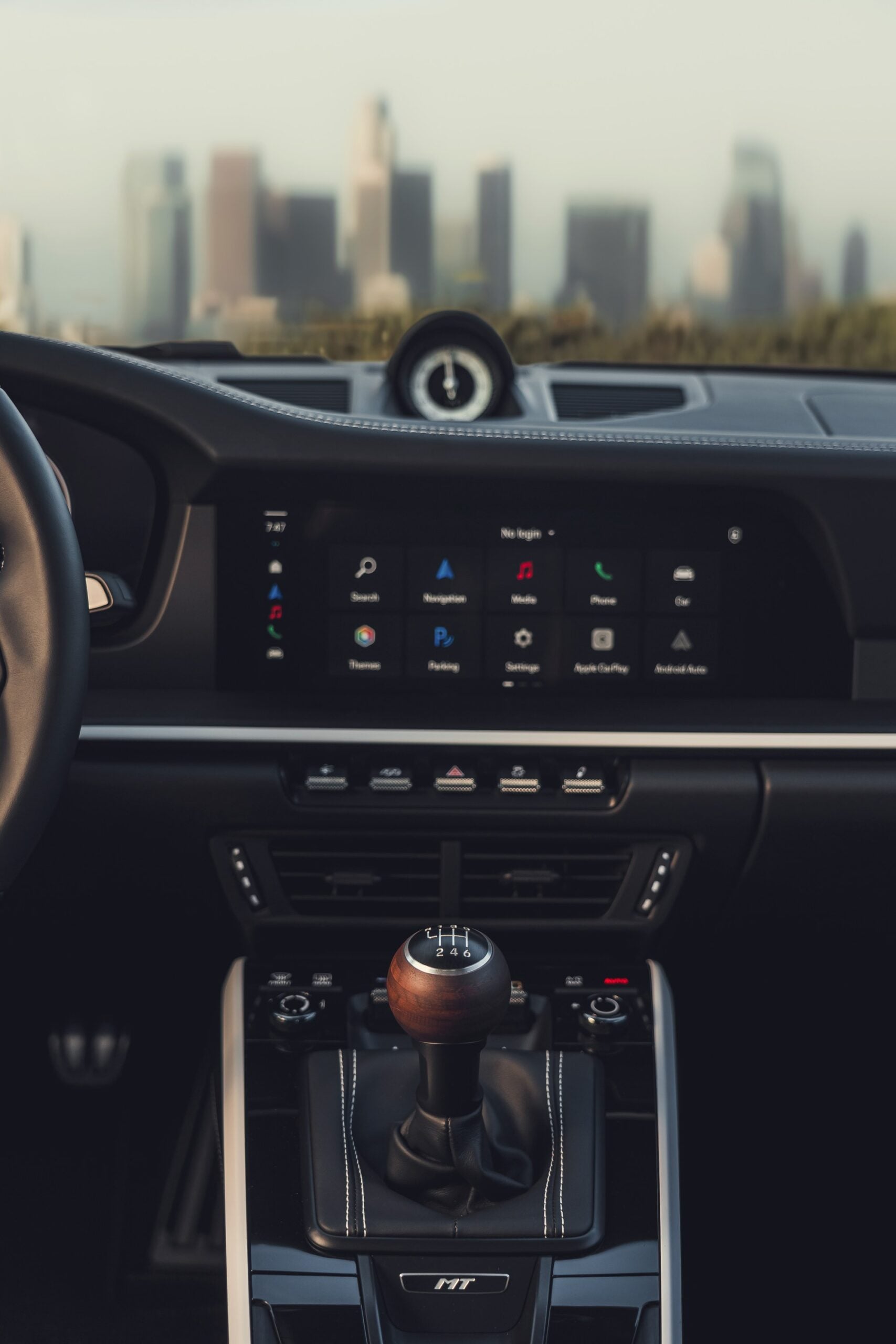 Official Porsche photo of the walnut six-speed shifter, MT console badge, and clutch pedal in the 2027 911 Carrera S with MT Package