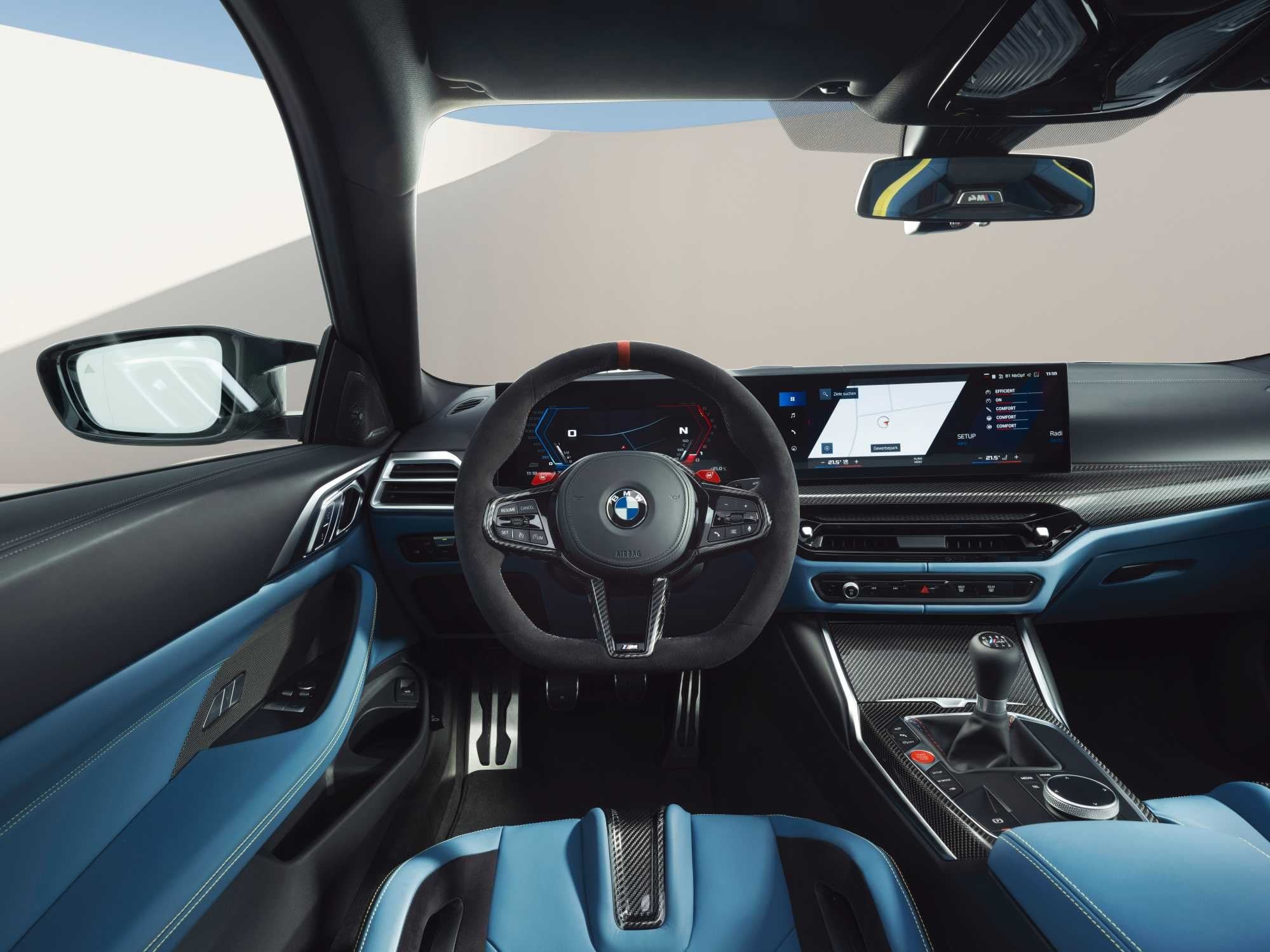 Official BMW photo of M4 Coupe cockpit with six-speed stick, three pedals, and M Carbon bucket seats
