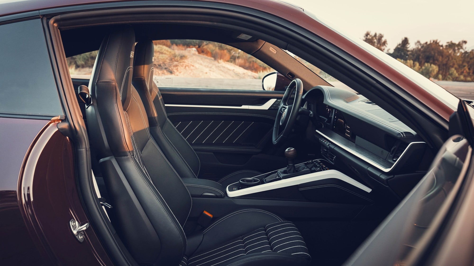 Official Porsche photo of the 2027 911 Carrera S with MT Package cabin showing the six-speed shifter and sport seats