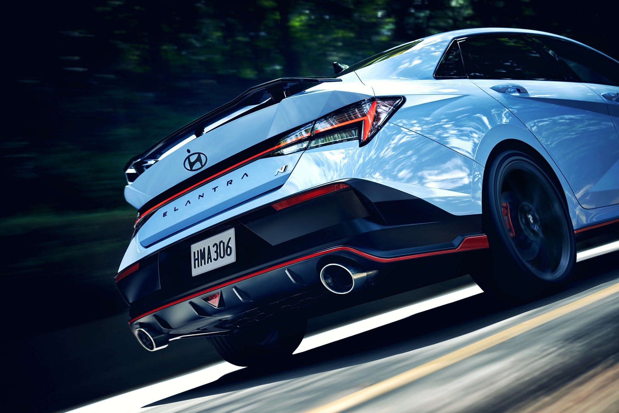 Official Hyundai photo of a Performance Blue 2026 Elantra N rear three-quarter in motion on a forest road