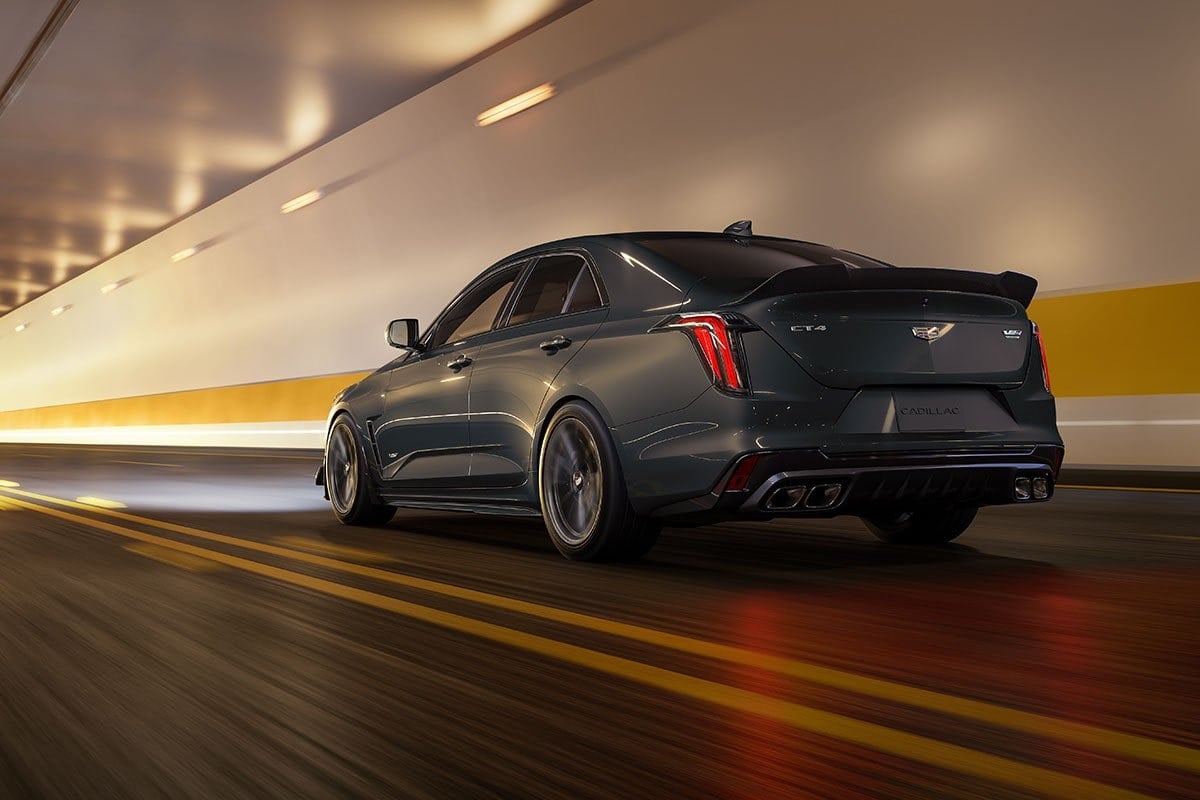 Official Cadillac photo of a 2026 CT4-V Blackwing rear three-quarter driving through a lit tunnel