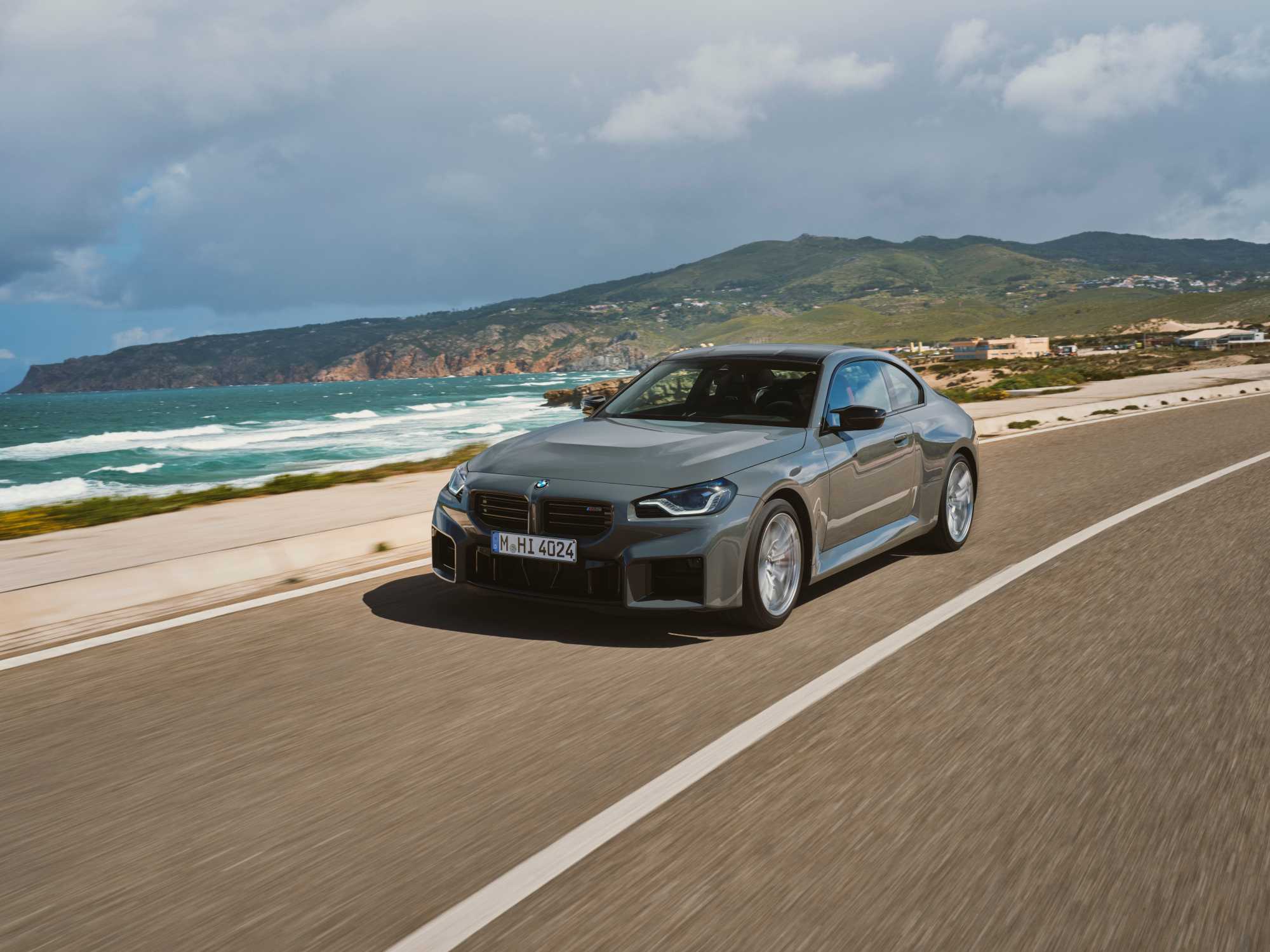 Official BMW photo of a grey BMW M2 Coupe rolling on a coastal road