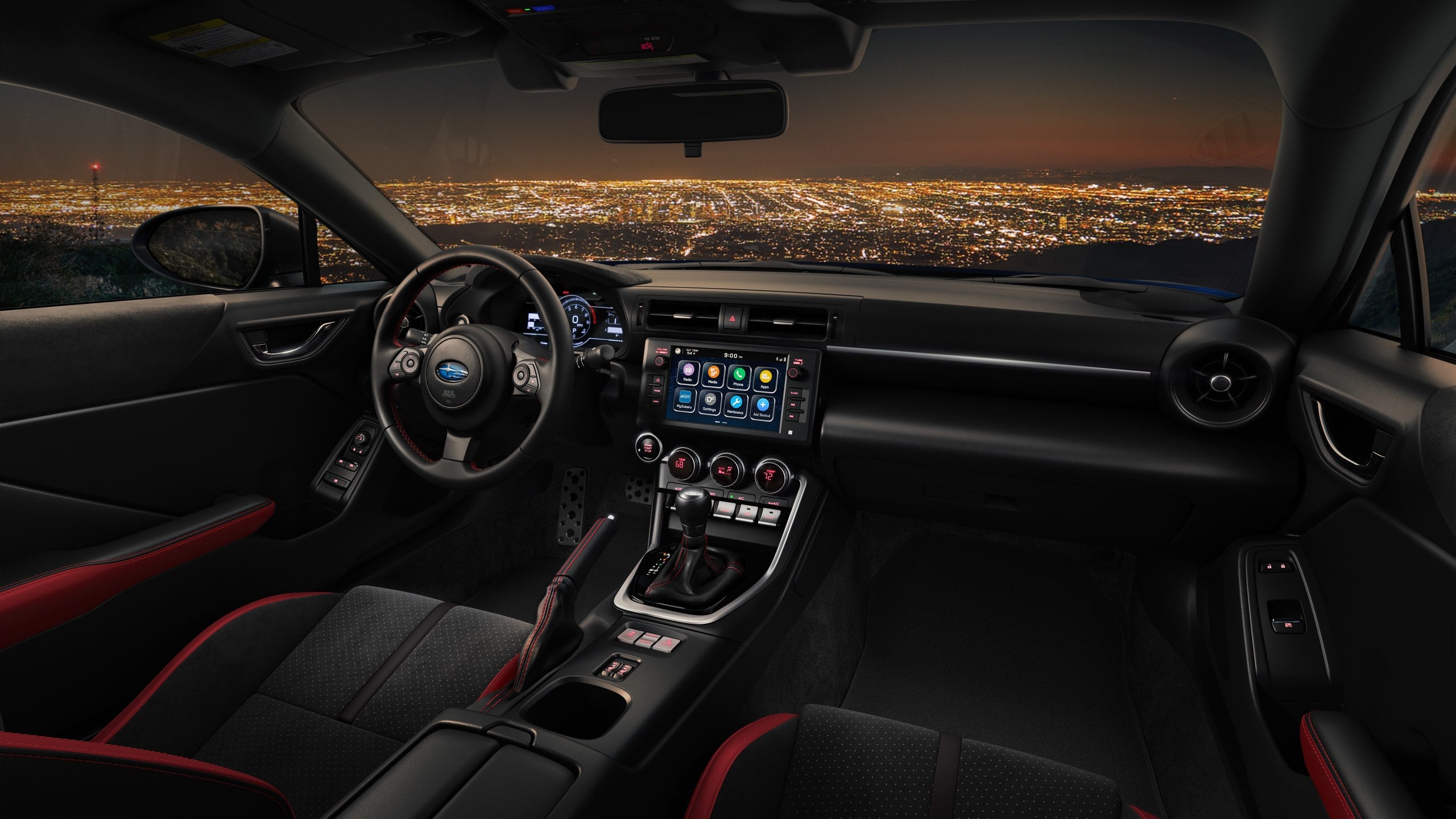 Official Subaru photo of a BRZ cabin with six-speed manual shifter overlooking a city at night