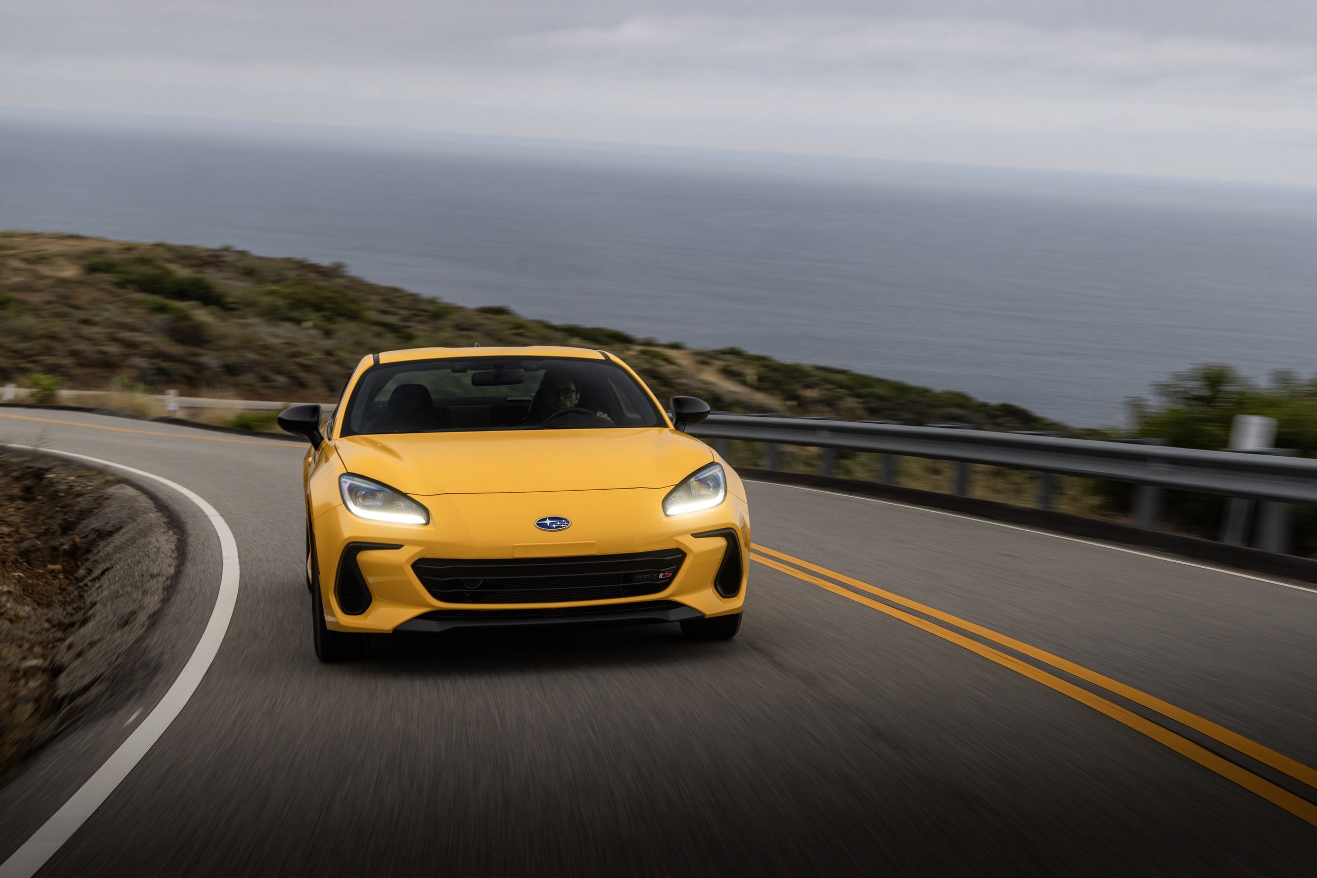 Official Subaru photo of a Sunrise Yellow BRZ tS front view on a coastal highway