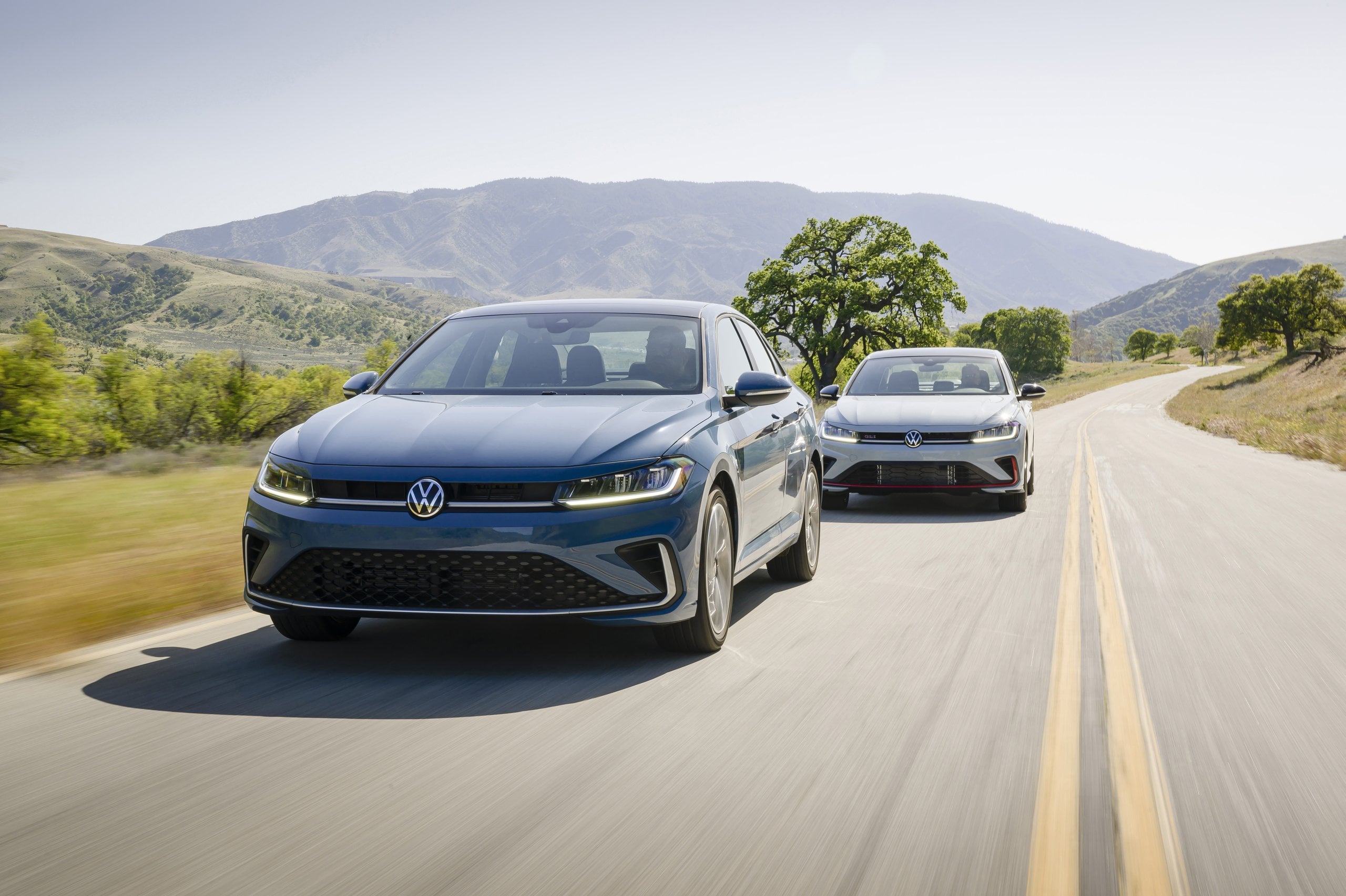 Official VW photo of blue Jetta and white Jetta GLI on a winding road