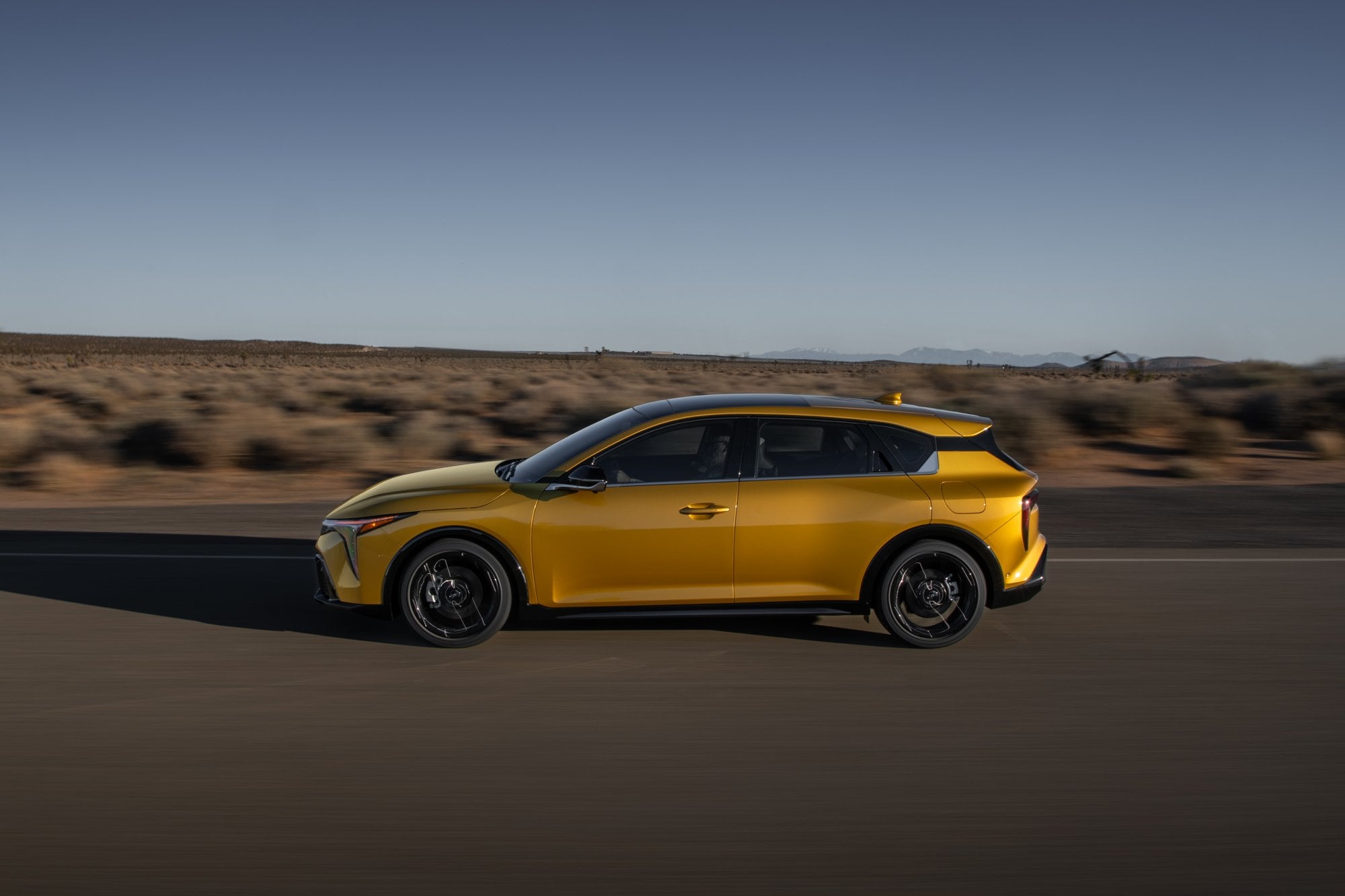 Official Kia photo of 2026 K4 Hatchback side profile in motion through desert