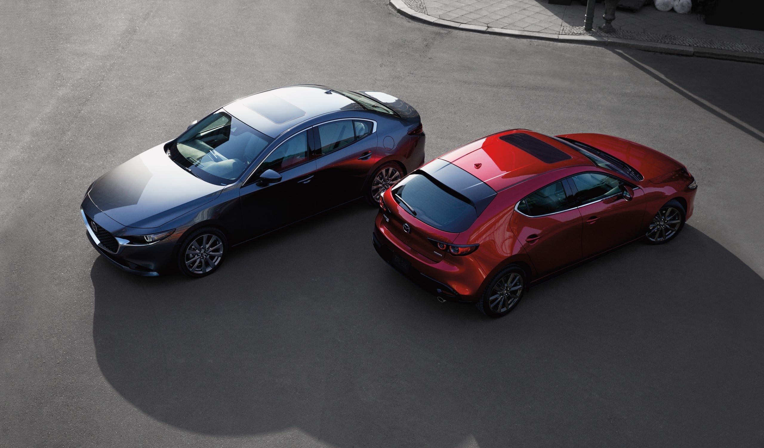 Official Mazda photo of a Mazda3 sedan and Soul Red hatchback from above