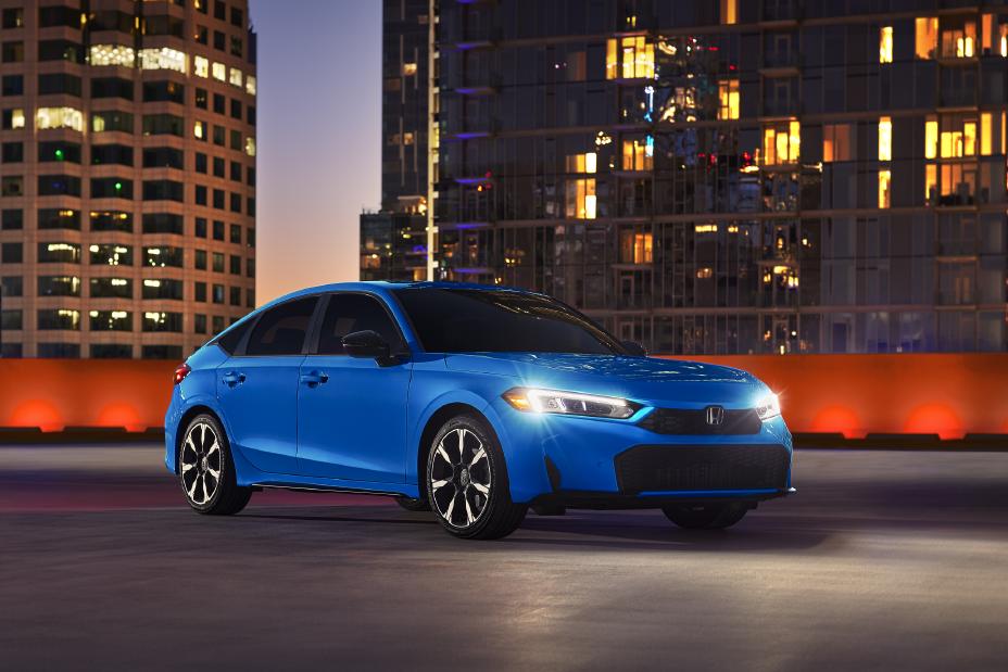 Official Honda photo of a Civic Hatchback front three-quarter at dusk with headlights on