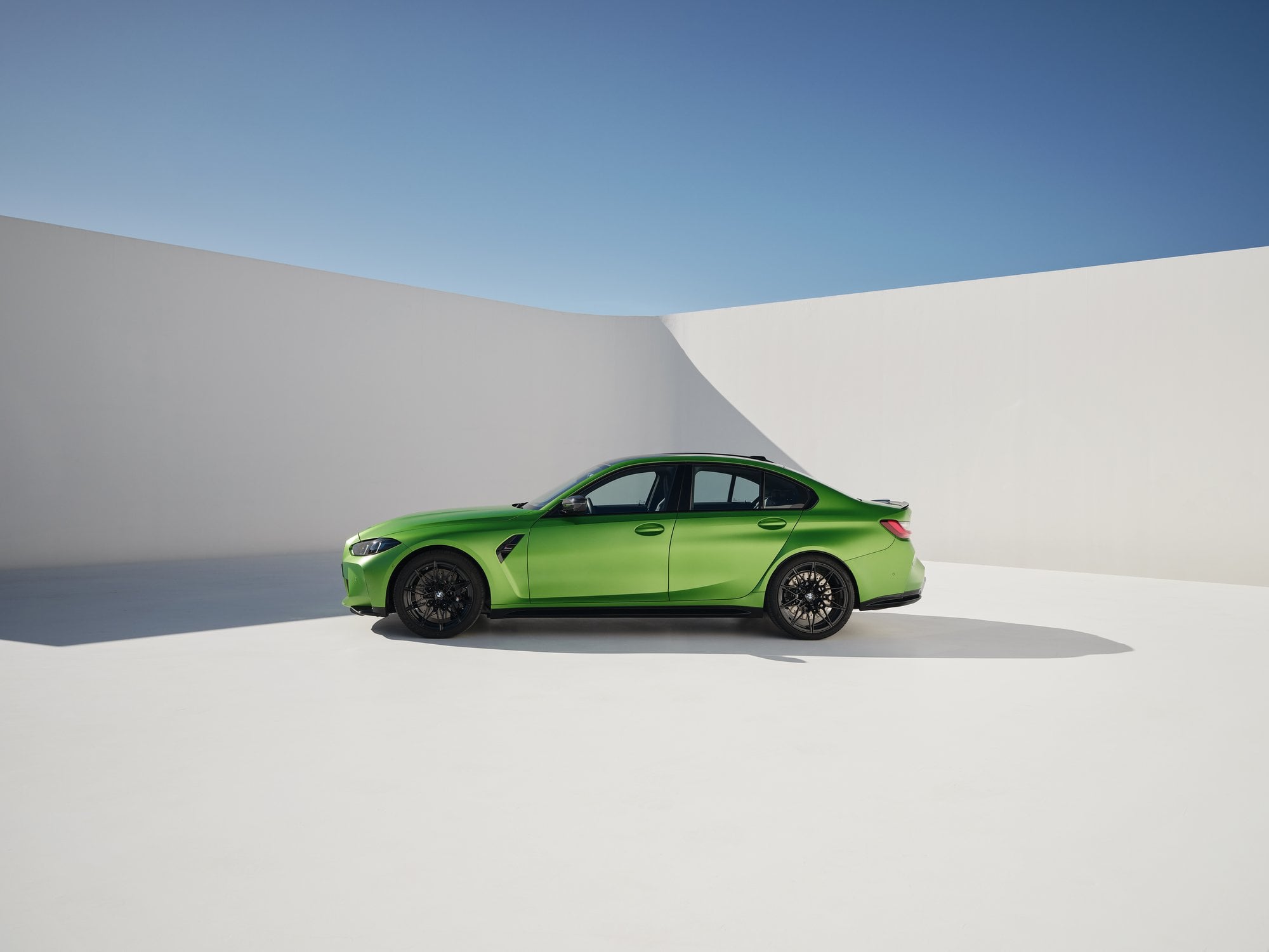 Official BMW press photo of the BMW M3 Sedan side profile in a white studio set