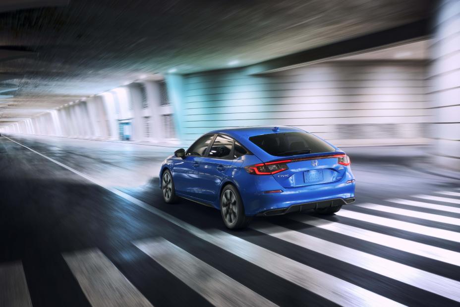 Official Honda photo of a Civic Hatchback rear three-quarter driving through a lit tunnel