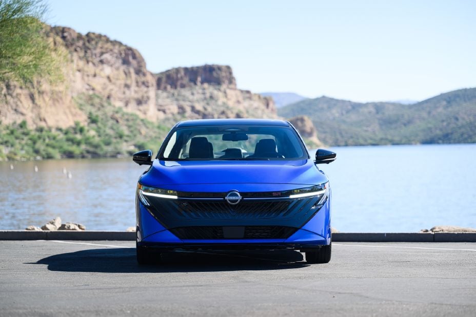 Official Nissan photo of a blue 2027 Nissan Sentra SR, head-on, parked in front of a lake