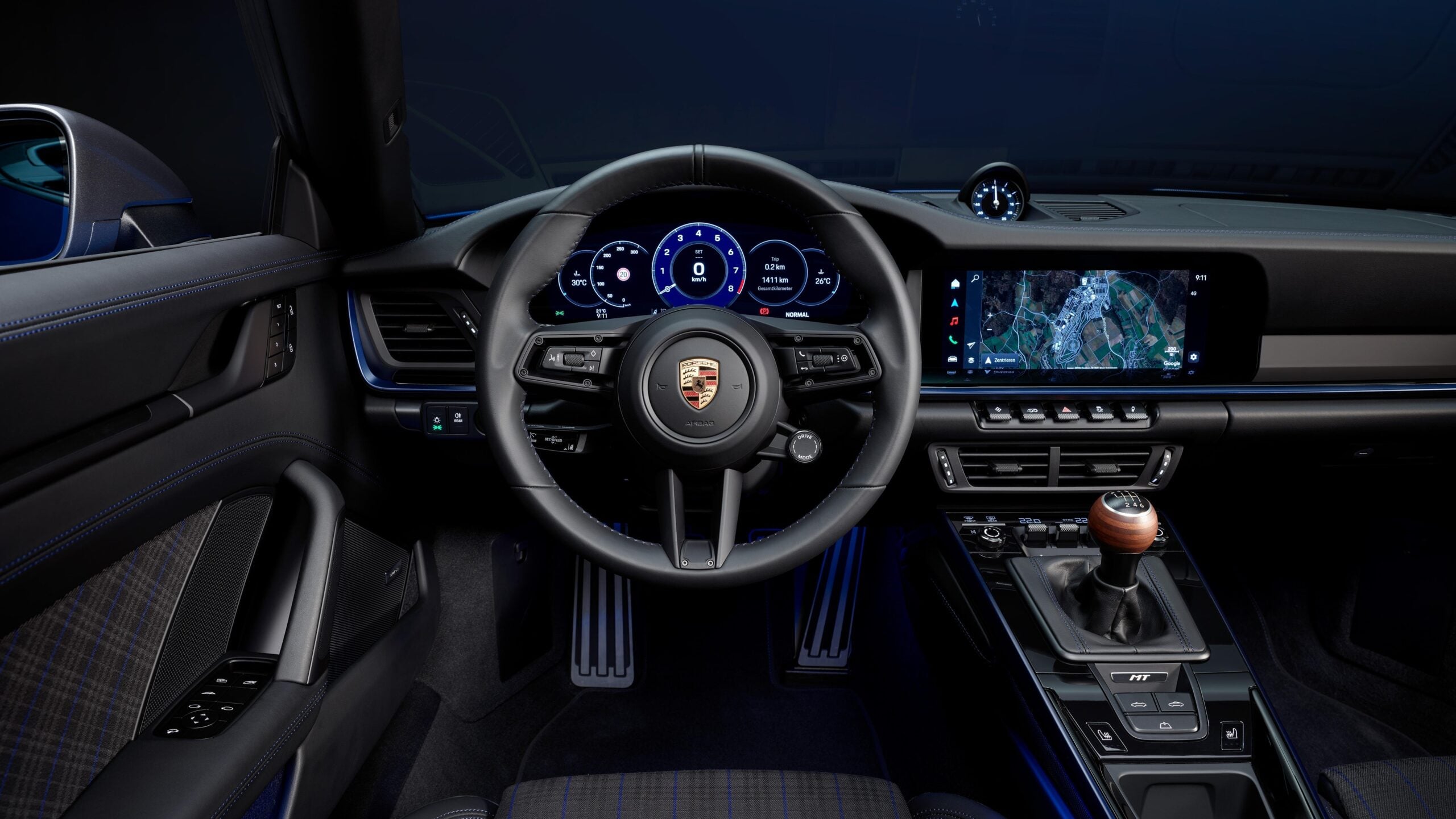 Official Porsche photo of 911 Carrera T cabin with walnut six-speed shifter, MT badge, and three pedals