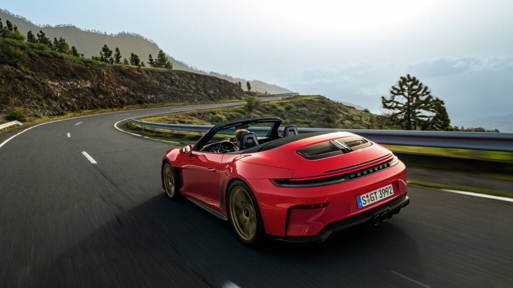 Official Porsche photo of the rear of a red 2027 Porsche 911 GT3 S/C with the top down on a curving road