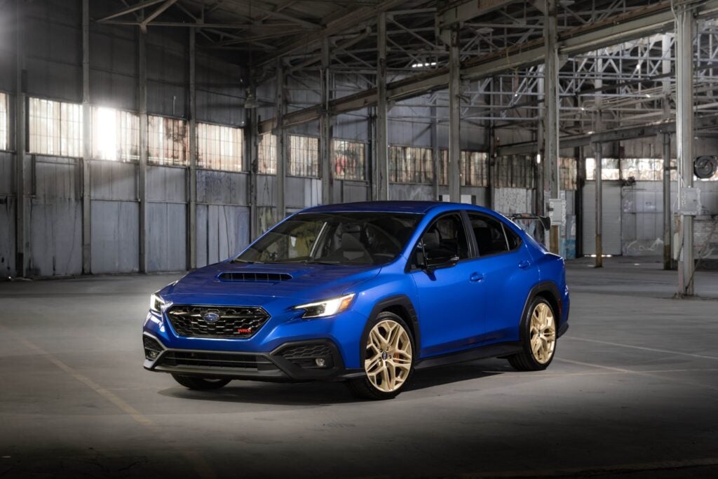 Official Subaru photo of the 2027 Subaru WRX GD25 front three-quarter in World Rally Blue with gold 19-inch wheels