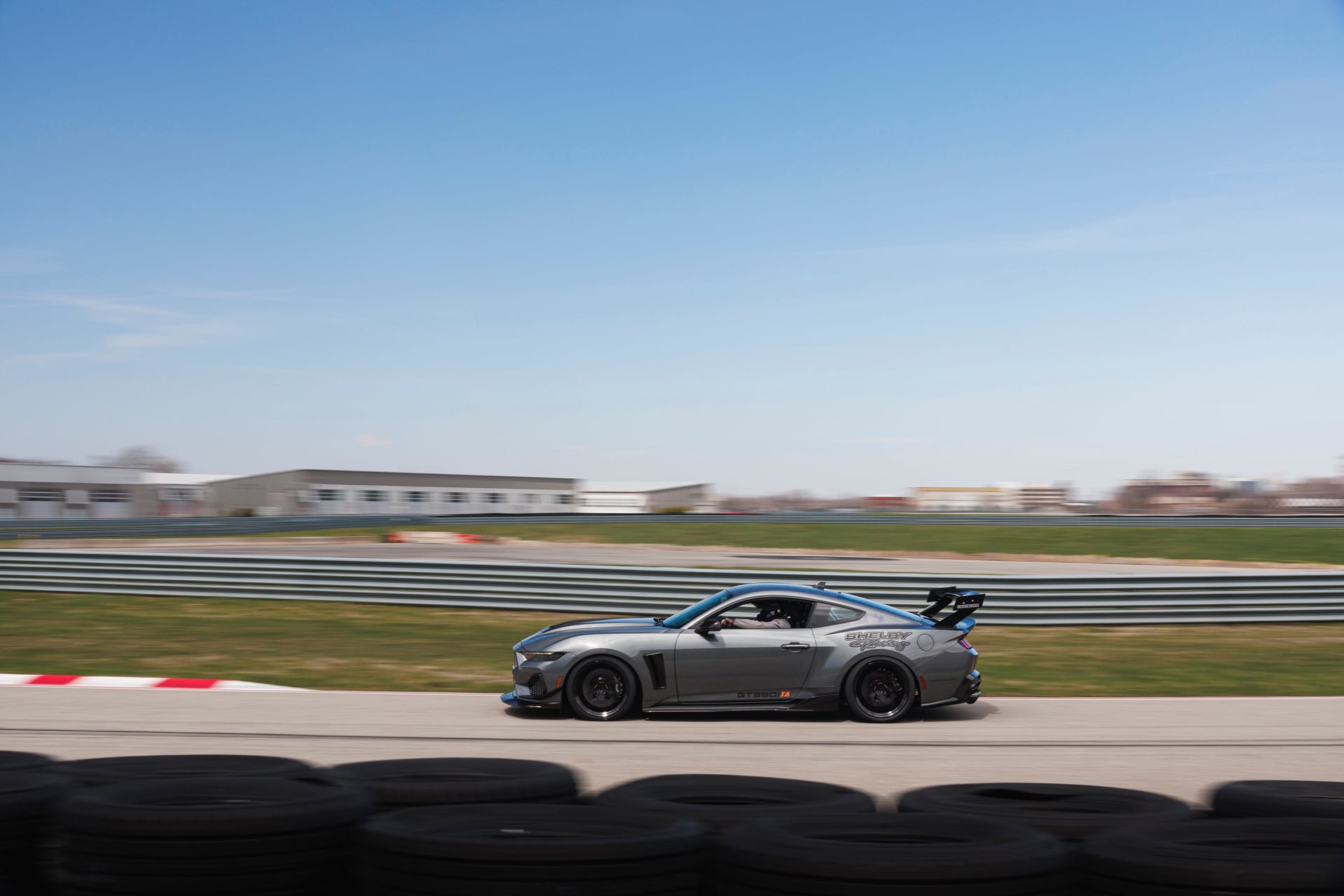 Official Shelby photo of a gray 2026 Shelby GT350/TA side profile in motion on track