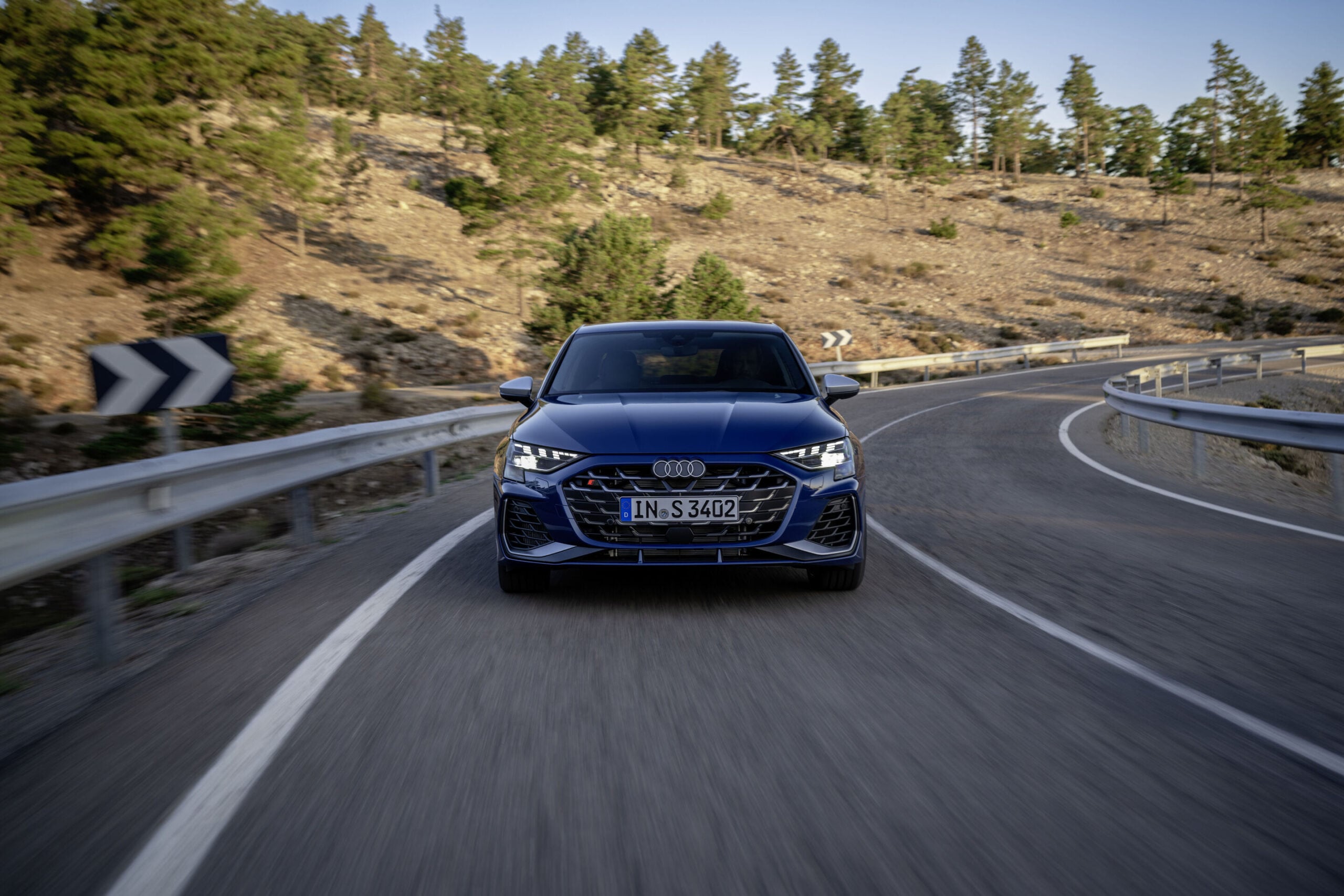 Official Audi photo of a dark blue 2026 Audi S3 head-on on a mountain road