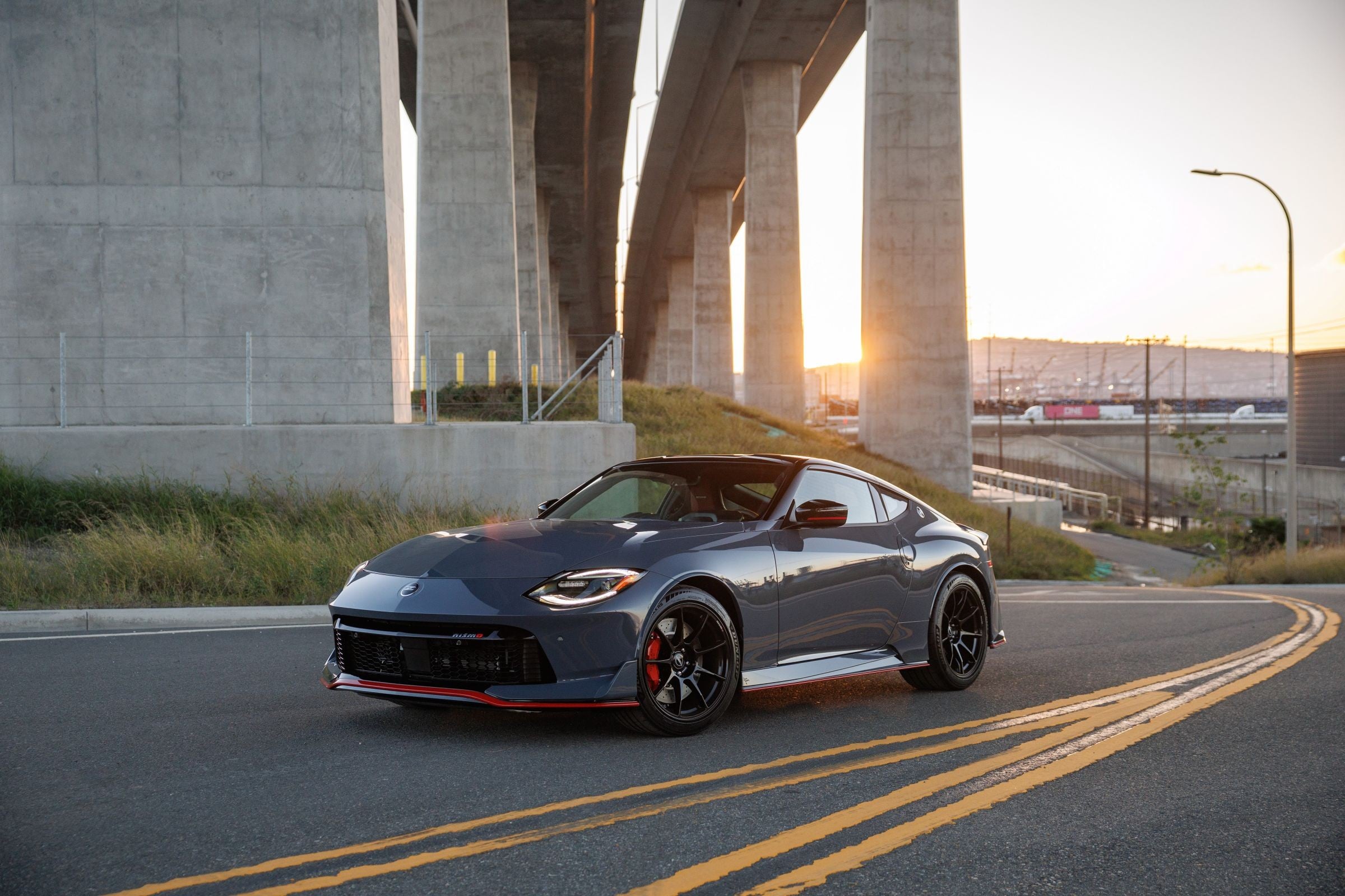 Official Nissan photo of a 2027 Nissan Z NISMO MT under a highway bridge at sunset